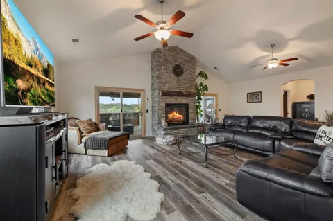 a living room with furniture a fireplace and a large window