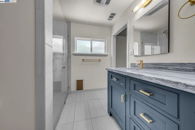 a spacious bathroom with a granite countertop sink and a mirror