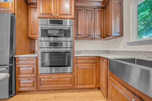 a kitchen with granite countertop a refrigerator and cabinets