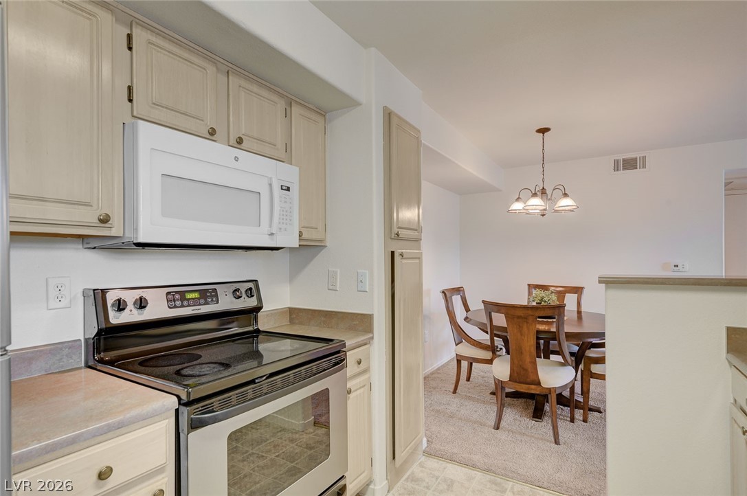 555 East Silverado Ranch Boulevard, Unit 2124 Las Vegas, NV 89183 - Photo 20 of 47 A compact kitchen with sleek appliances seamlessly transitions into a cozy dining area, ideal for daily meals.