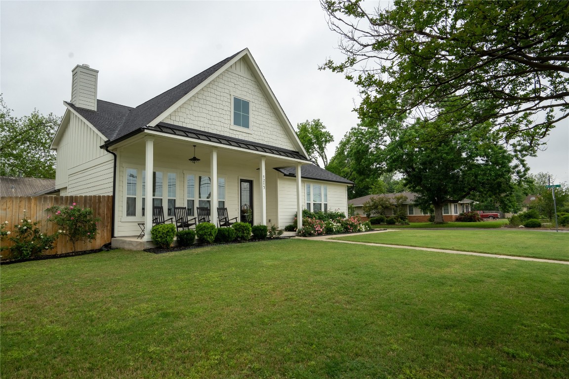 a front view of a house with a yard and trees