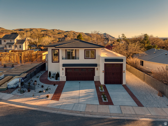 226 East 1100 North Hurricane, UT 84737 - Photo 3 of 49 View of front of house featuring stucco siding, concrete driveway, a tiled roof, an attached garage, and stone siding