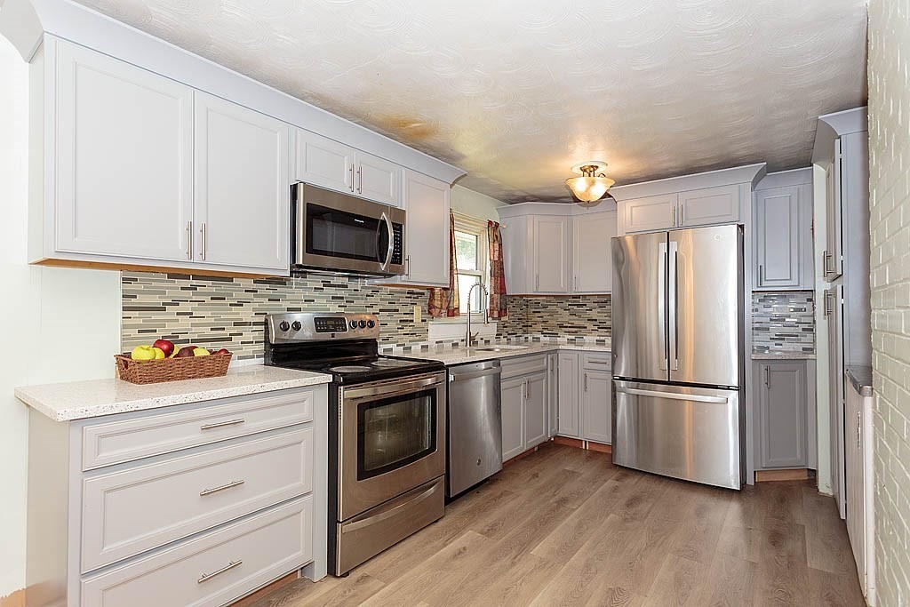 38 McDevitt Road Randolph, MA 02368 - Photo 4 of 22 a kitchen with granite countertop a refrigerator stove and sink