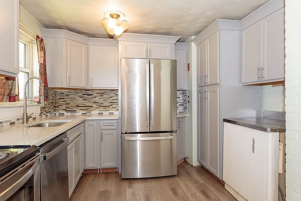 38 McDevitt Road Randolph, MA 02368 - Photo 5 of 22 a kitchen with granite countertop a refrigerator sink and cabinets