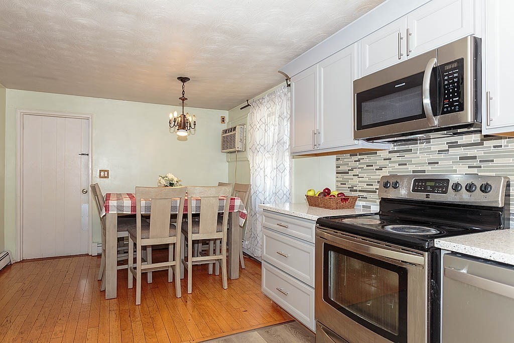 38 McDevitt Road Randolph, MA 02368 - Photo 6 of 22 a kitchen with stainless steel appliances a stove a microwave and white cabinets