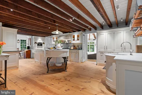 a living room with stainless steel appliances granite countertop furniture and a wooden floors