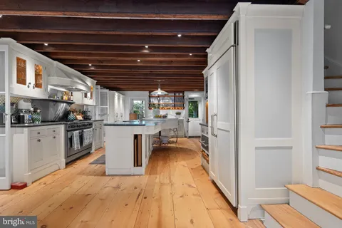 a kitchen with a refrigerator and white cabinets