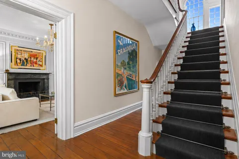 a view of an entryway with wooden floor stairs and a living room