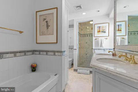 a bathroom with a tub a sink and a mirror