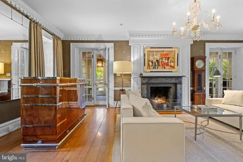 a living room with furniture a fireplace and a chandelier