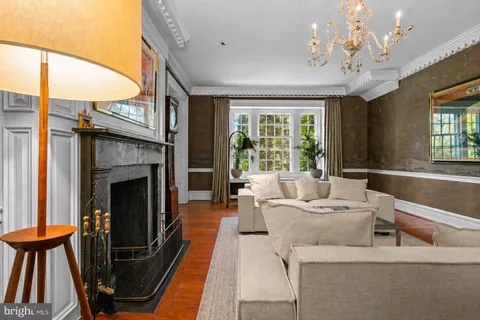 a living room with furniture a fireplace and a chandelier