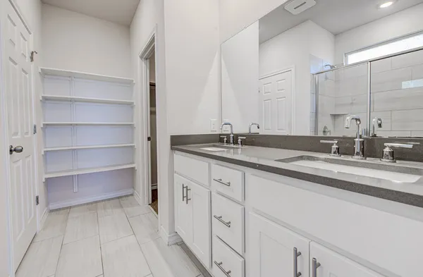 a bathroom with a double vanity sink and a mirror