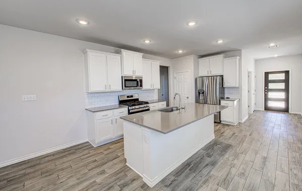 a large white kitchen with wooden floor