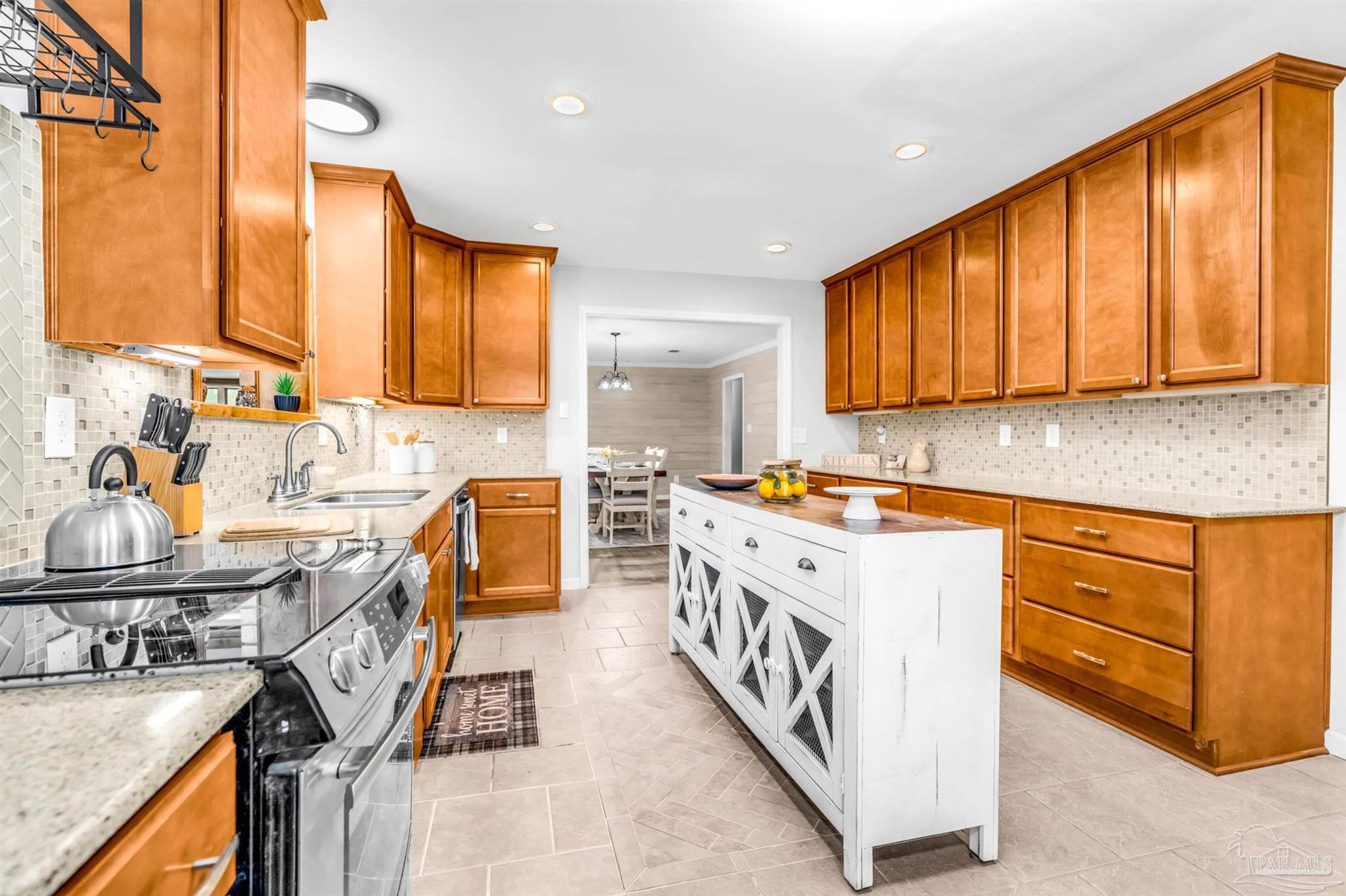 6912 Kitty Hawk Drive Pensacola, FL 32506 - Photo 25 of 61 a kitchen with a sink stove and cabinets