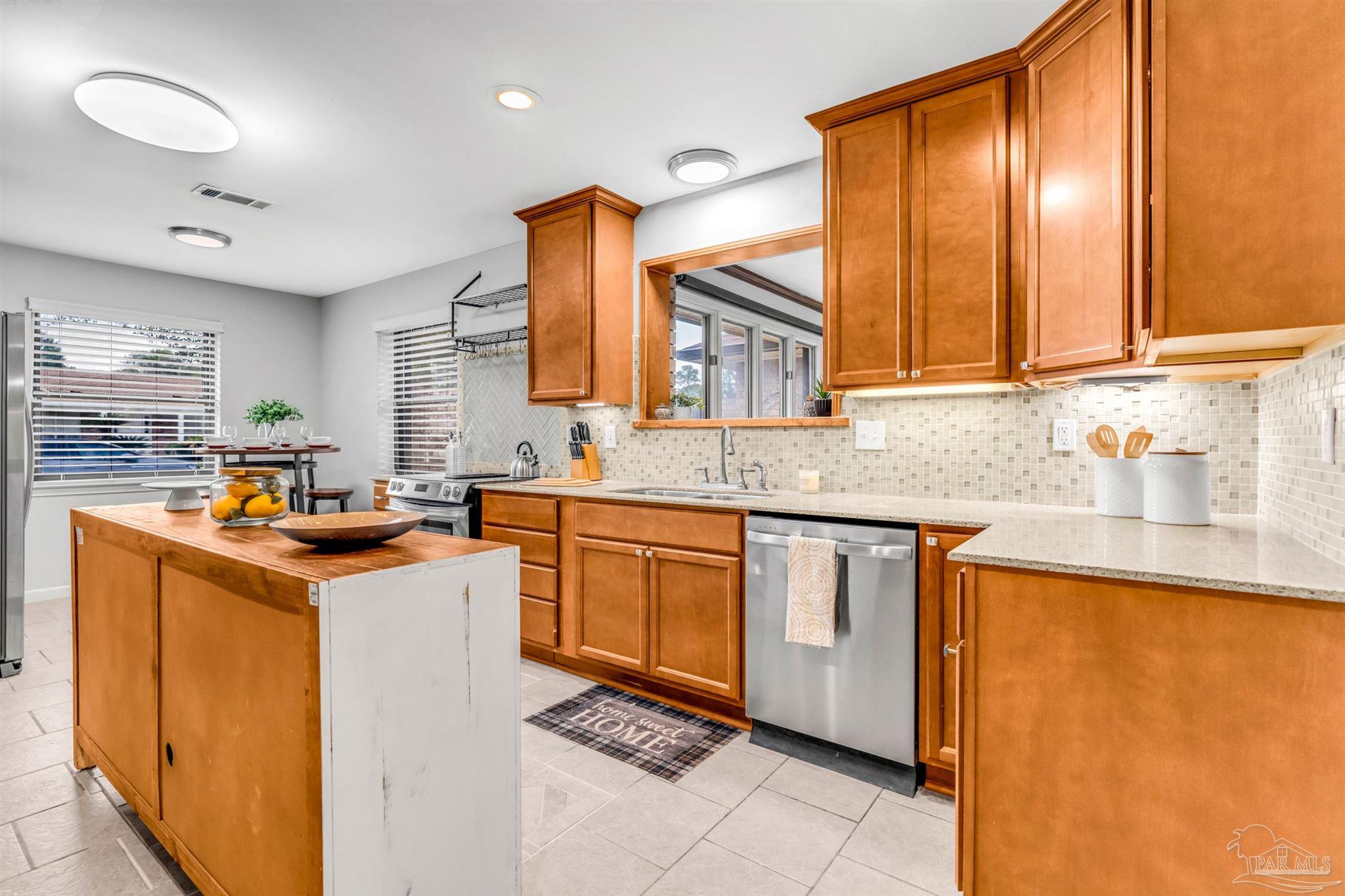 6912 Kitty Hawk Drive Pensacola, FL 32506 - Photo 27 of 61 a kitchen with stainless steel appliances granite countertop a sink stove and cabinets