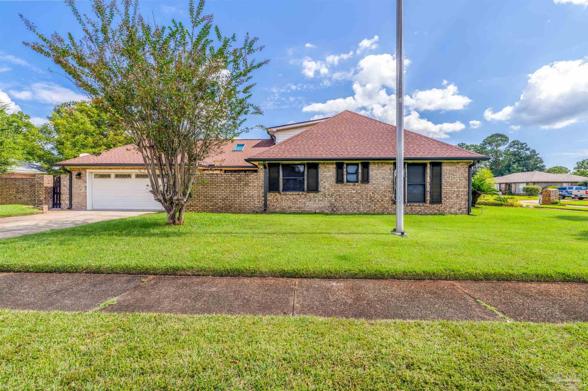 6912 Kitty Hawk Drive Pensacola, FL 32506 - Photo 4 of 61 a front view of a house with a yard and garage
