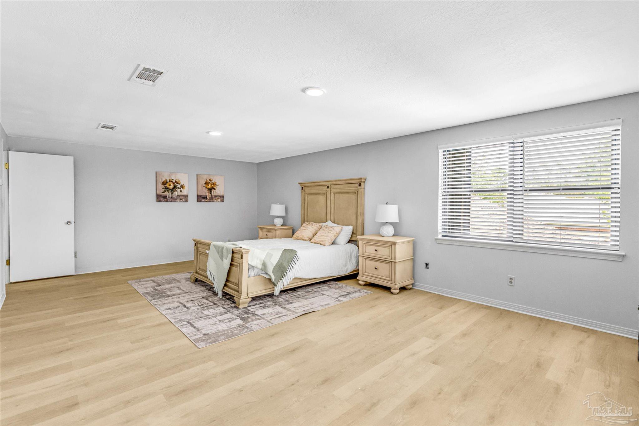 6912 Kitty Hawk Drive Pensacola, FL 32506 - Photo 42 of 61 a spacious bedroom with a bed and wooden floor