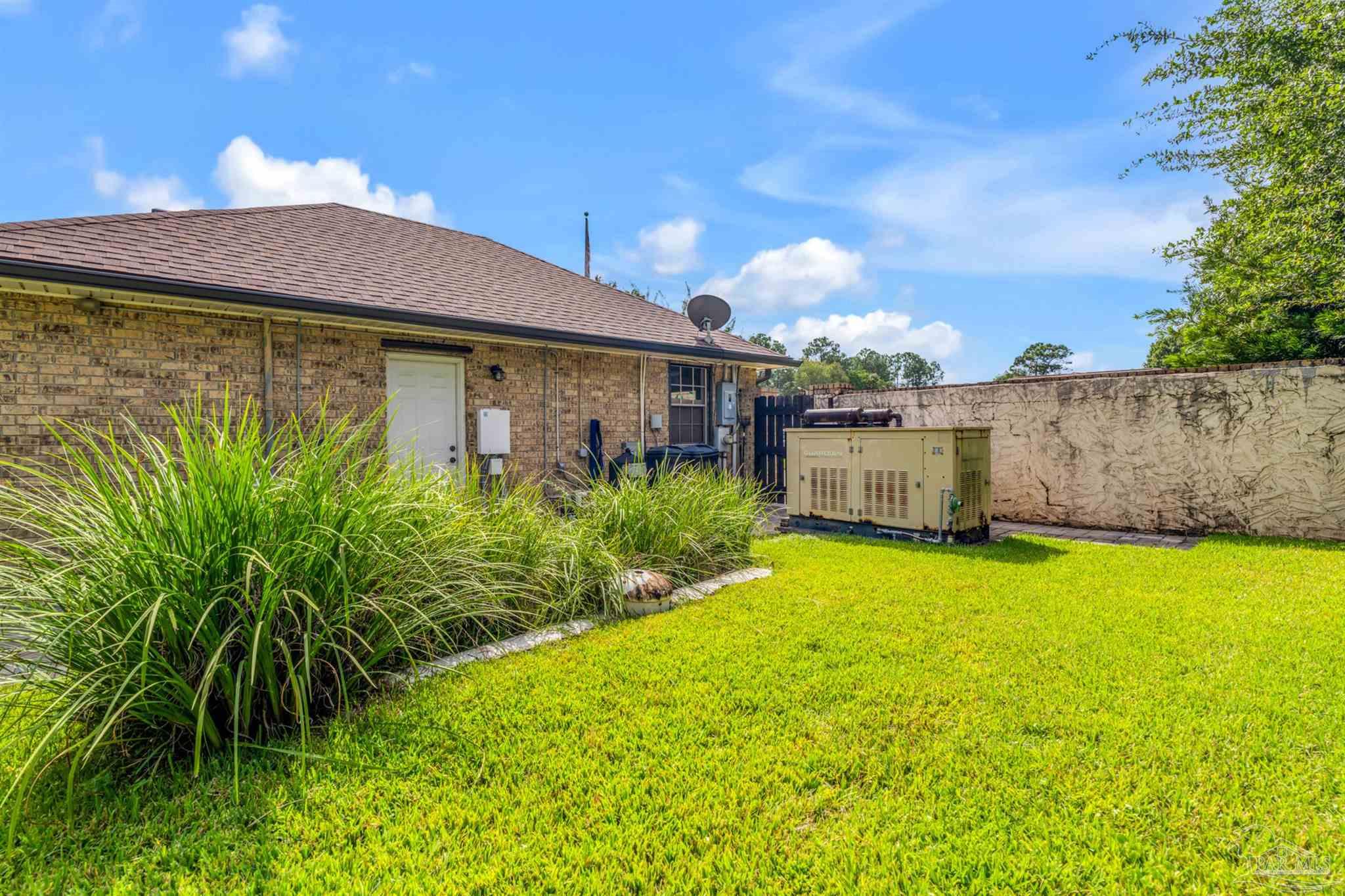 6912 Kitty Hawk Drive Pensacola, FL 32506 - Photo 53 of 61 a view of a backyard with plants and a patio