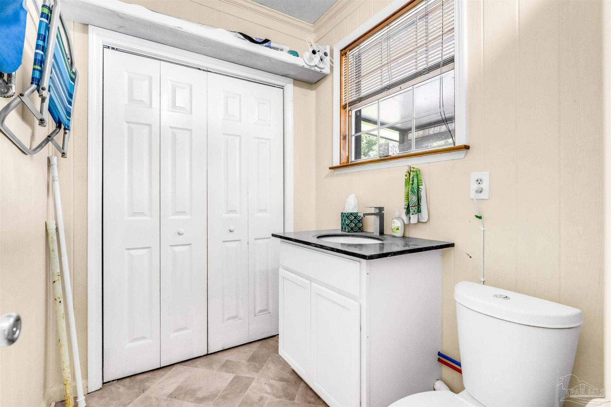 6912 Kitty Hawk Drive Pensacola, FL 32506 - Photo 58 of 61 a bathroom with a granite countertop sink toilet and a mirror
