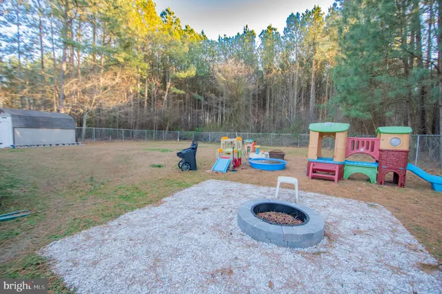 a backyard of a house with sofas fire pit and outdoor seating