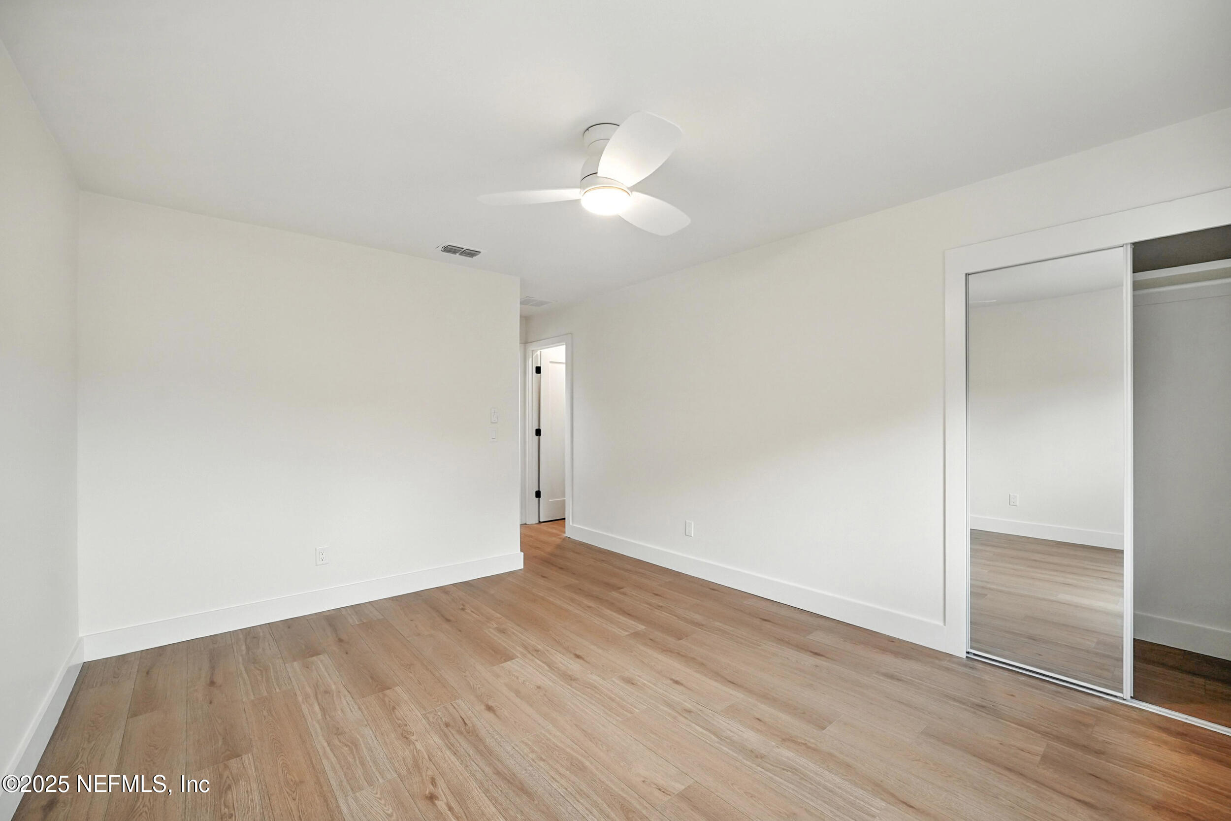 573 Aquatic Drive Atlantic Beach, FL 32233 - Photo 17 of 26 an empty room with wooden floor and windows