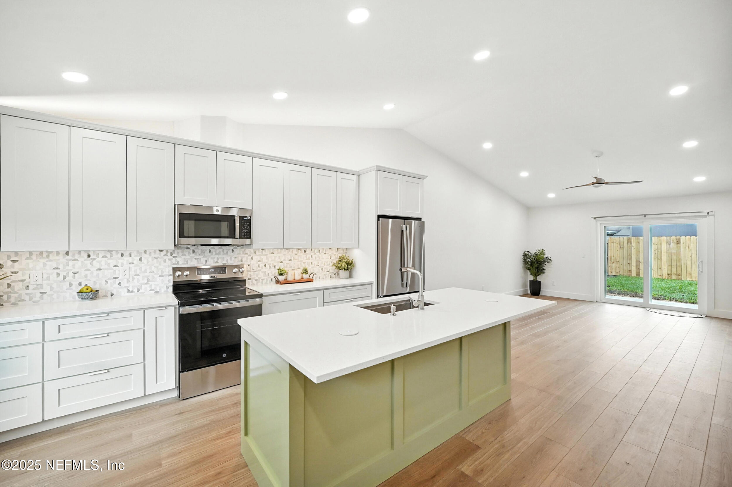 573 Aquatic Drive Atlantic Beach, FL 32233 - Photo 7 of 26 a kitchen with stainless steel appliances a stove a sink a refrigerator white cabinets and wooden floor