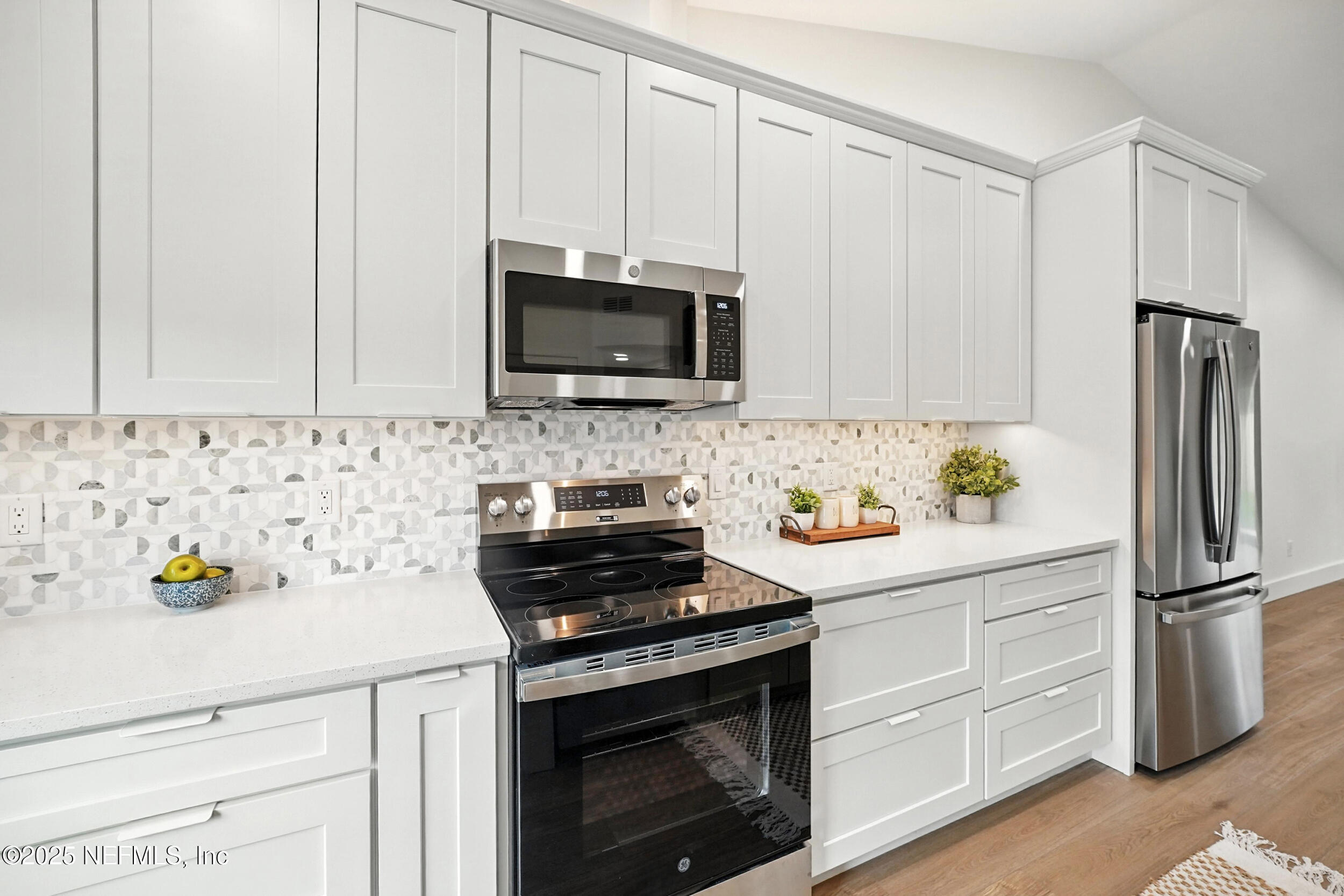573 Aquatic Drive Atlantic Beach, FL 32233 - Photo 8 of 26 a kitchen with granite countertop white cabinets and stainless steel appliances