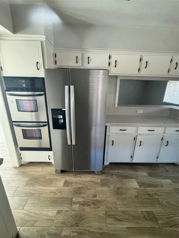 a kitchen with kitchen island a sink appliances and cabinets