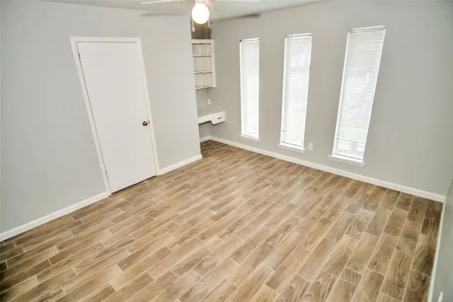 a view of empty room with wooden floor