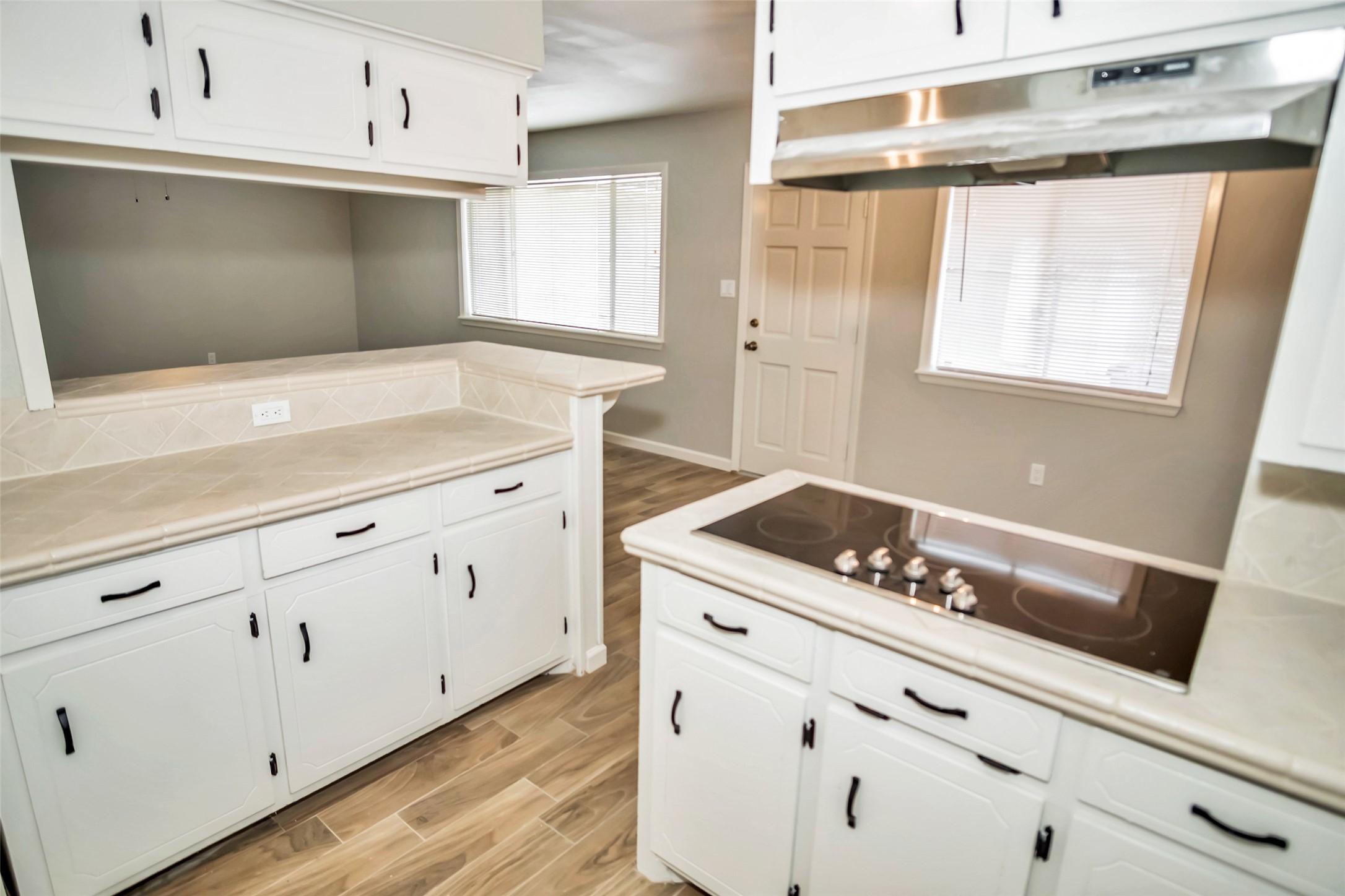 1715 Capstan Road Houston, TX 77062 - Photo 10 of 40 a kitchen with white cabinets and a stove with wooden floor