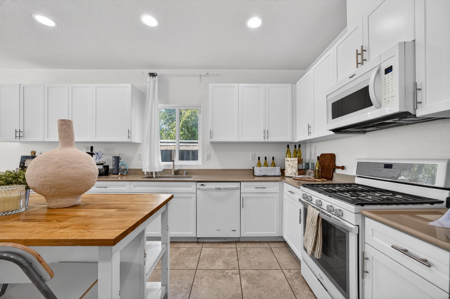 7620 Ferrell Way Elk Grove, CA 95757 - Photo 24 of 75 a kitchen with stainless steel appliances granite countertop a stove a sink dishwasher and white cabinets with wooden floor
