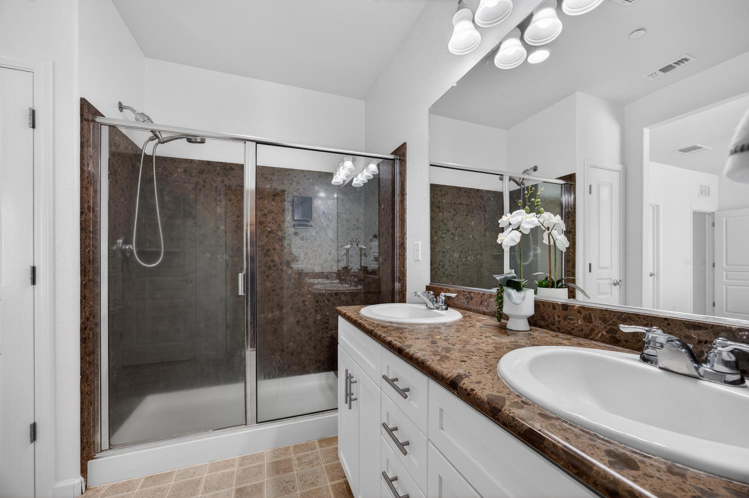 7620 Ferrell Way Elk Grove, CA 95757 - Photo 38 of 75 a bathroom with a granite countertop sink a mirror and shower