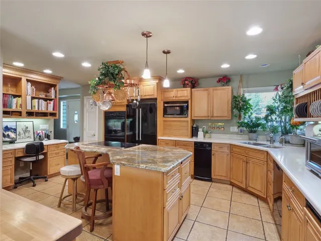 a kitchen with stainless steel appliances kitchen island granite countertop a sink and cabinets