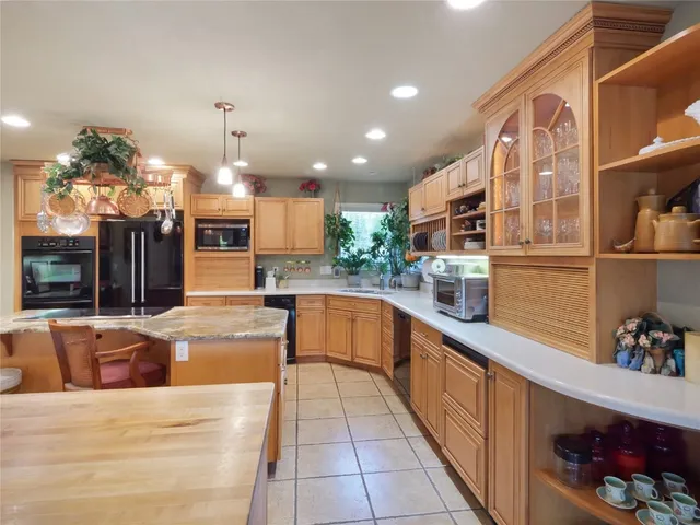 a large kitchen with stainless steel appliances kitchen island granite countertop a sink and cabinets