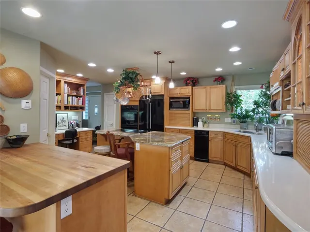 a large kitchen with counter top space and stainless steel appliances