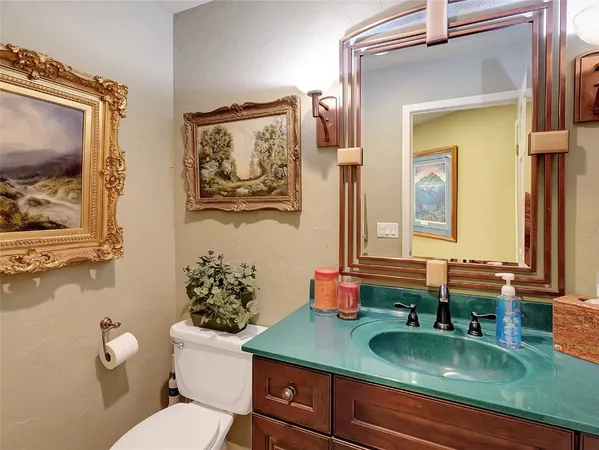 a bathroom with a granite countertop sink mirror vanity and toilet