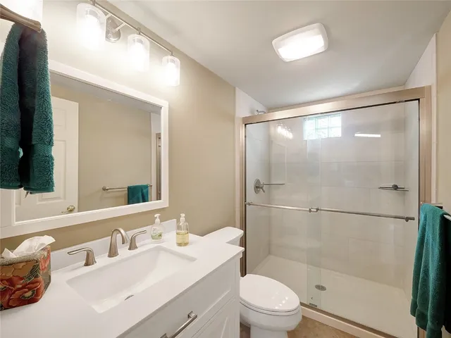 a bathroom with a sink mirror toilet and shower