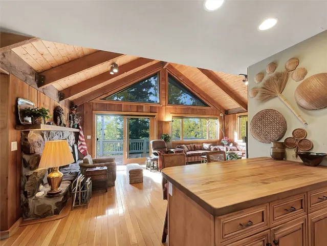 a kitchen with stainless steel appliances granite countertop a stove top oven a dining table and chairs with wooden floor