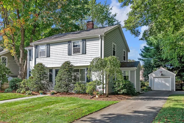 a front view of a house with a yard and trees