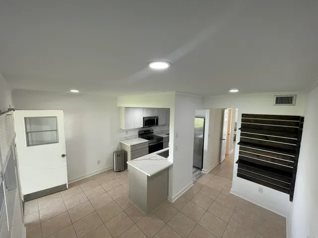 a view of kitchen with furniture and refrigerator