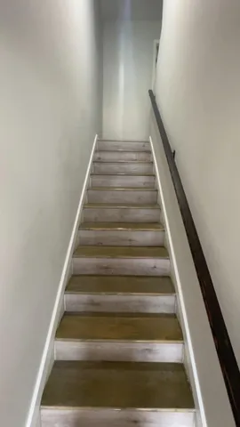 a view of a livingroom with wooden floor and staircase