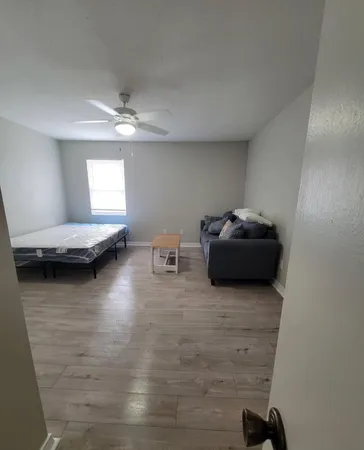 a bedroom with a bed and wooden floor