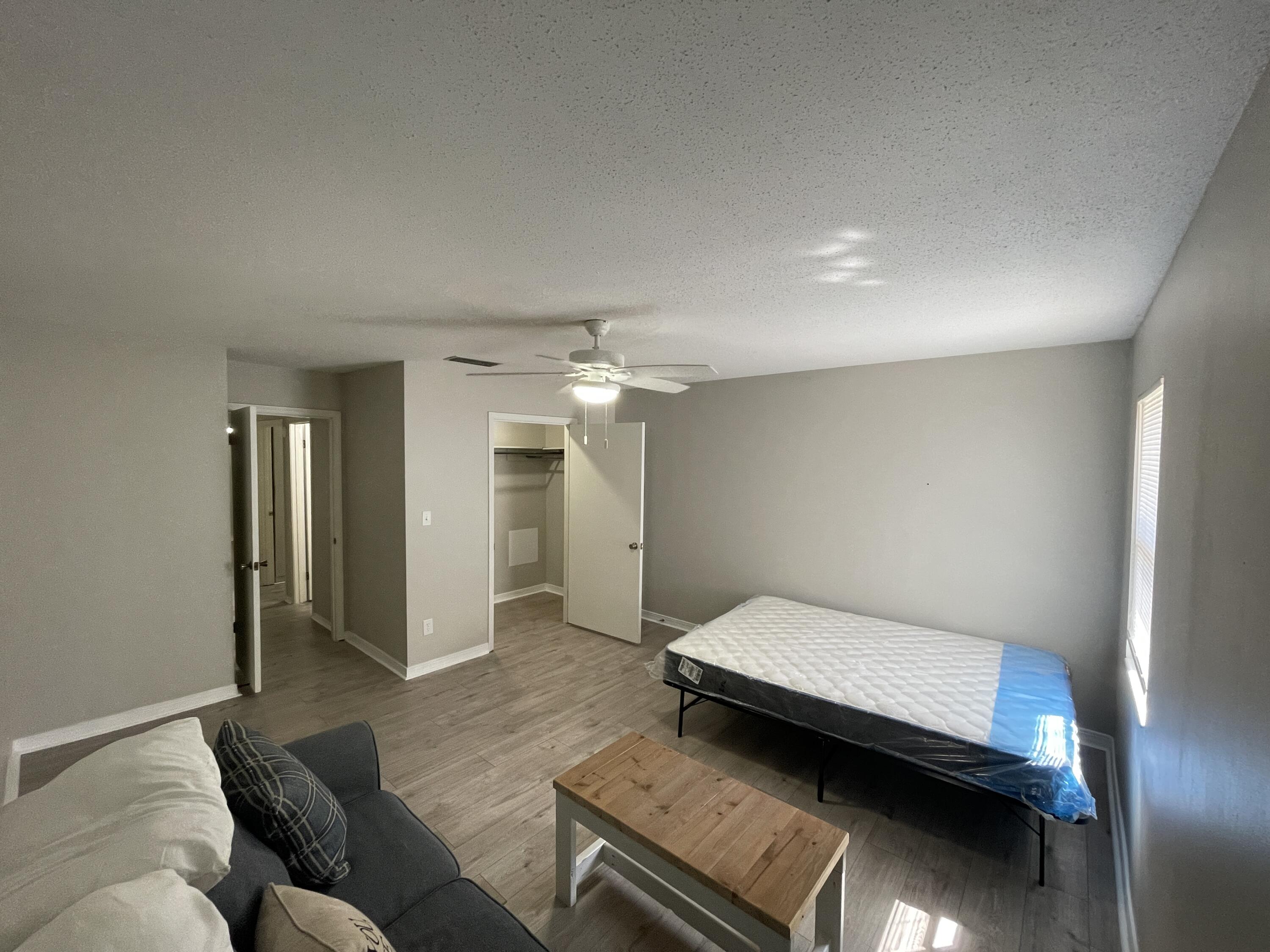 145 4th Avenue, Unit B3 Shalimar, FL 32579 - Photo 39 of 46 a bedroom with a bed and wooden floor