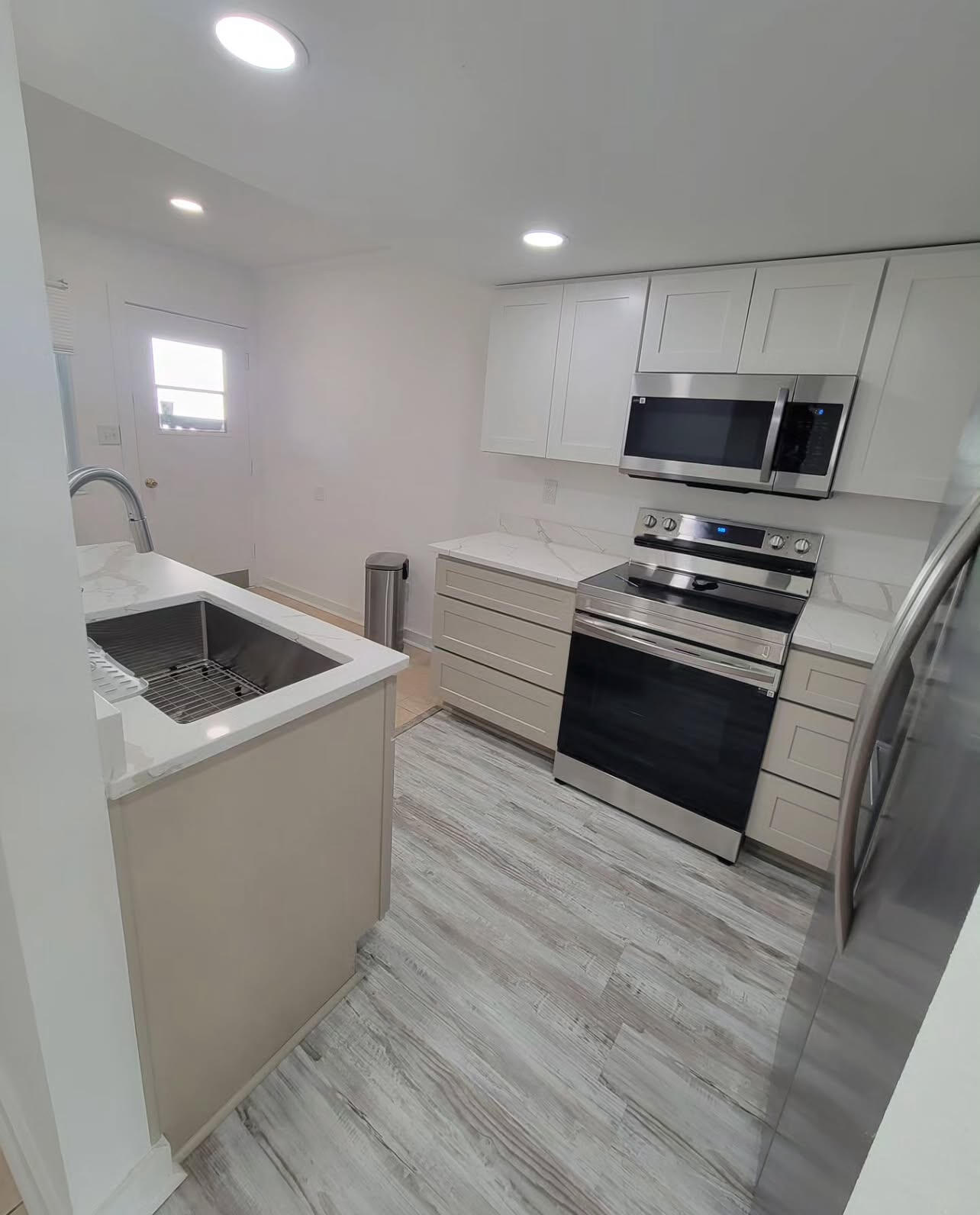 145 4th Avenue, Unit B3 Shalimar, FL 32579 - Photo 9 of 46 a kitchen with stainless steel appliances a stove a microwave a sink and white cabinets