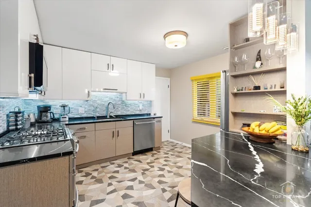 a kitchen with stainless steel appliances granite countertop a sink stove and cabinets