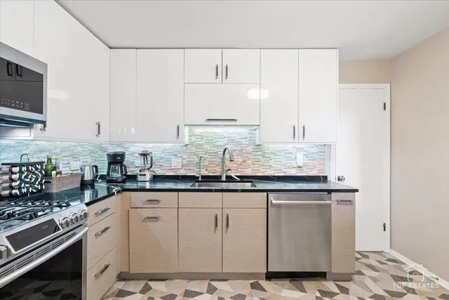 a kitchen with granite countertop a sink stove and cabinets