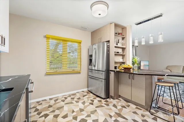 a kitchen with stainless steel appliances granite countertop a refrigerator and a stove top oven