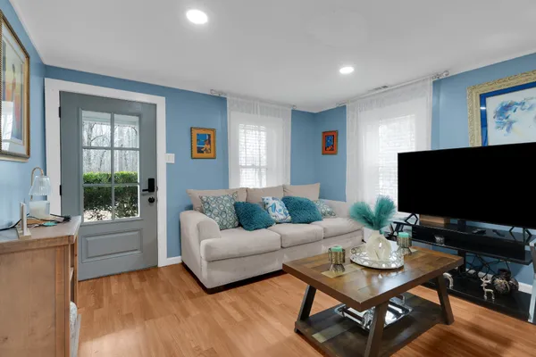 a kitchen with stainless steel appliances granite countertop a stove a sink a microwave a center island and a wooden floor