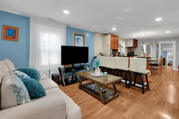 a kitchen with stainless steel appliances granite countertop wooden floors stove refrigerator and microwave