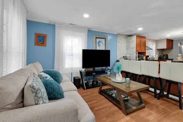 a kitchen with stainless steel appliances granite countertop a refrigerator a stove and a wooden floor